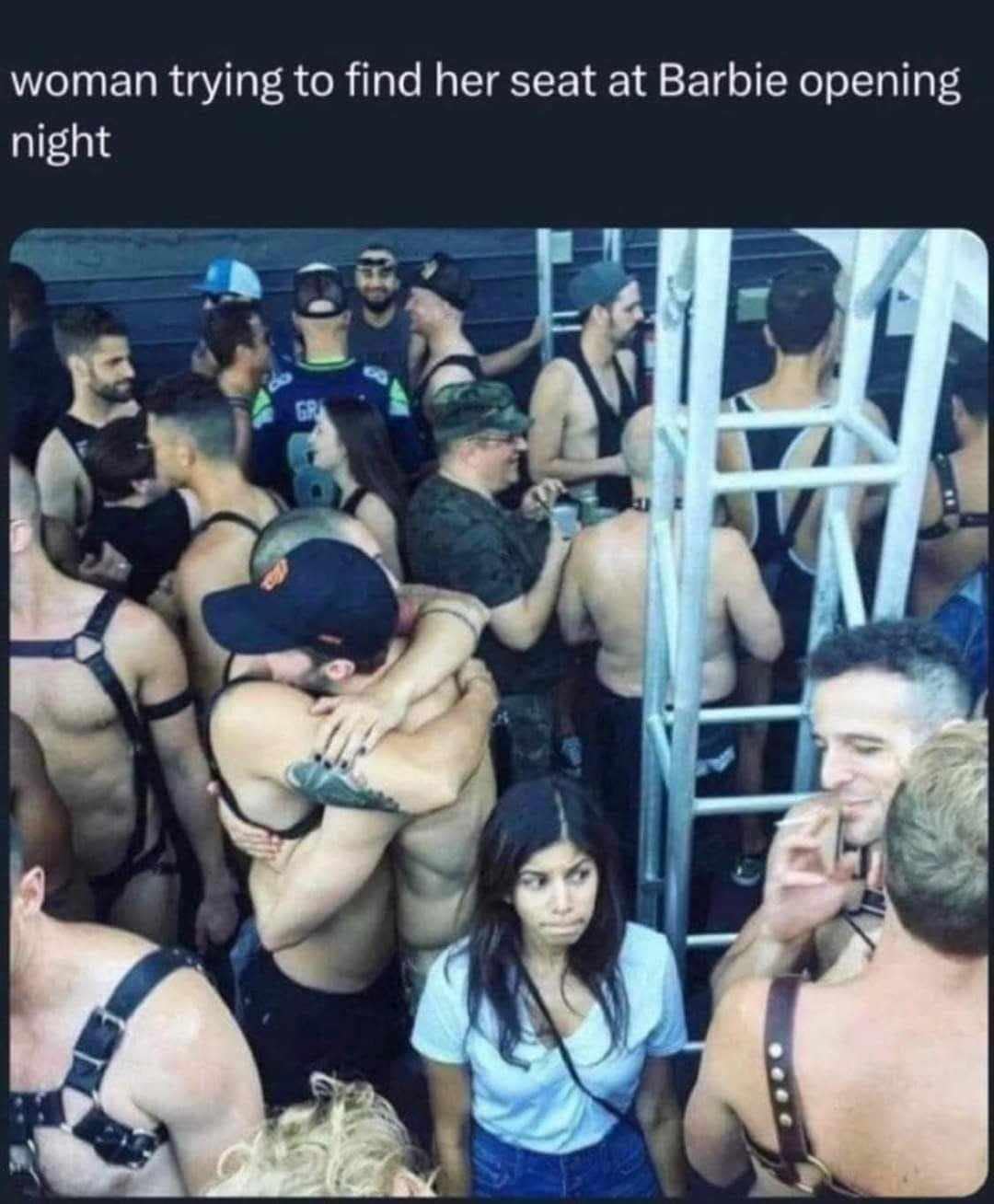 This meme is an image of a crowded, dimly lit nightclub or bar, with people dancing and interacting with each other. The text "woman trying to find her seat at Barbie movie premiere" is at the top, and the caption "woman trying to find her seat at Barbie movie premiere" is at the bottom. The image is a humorous commentary on the crowded and chaotic nature of a popular event, with the added twist of the woman's struggle to find her seat being juxtaposed with the idea of a movie premiere, which is typically a more formal and structured event.